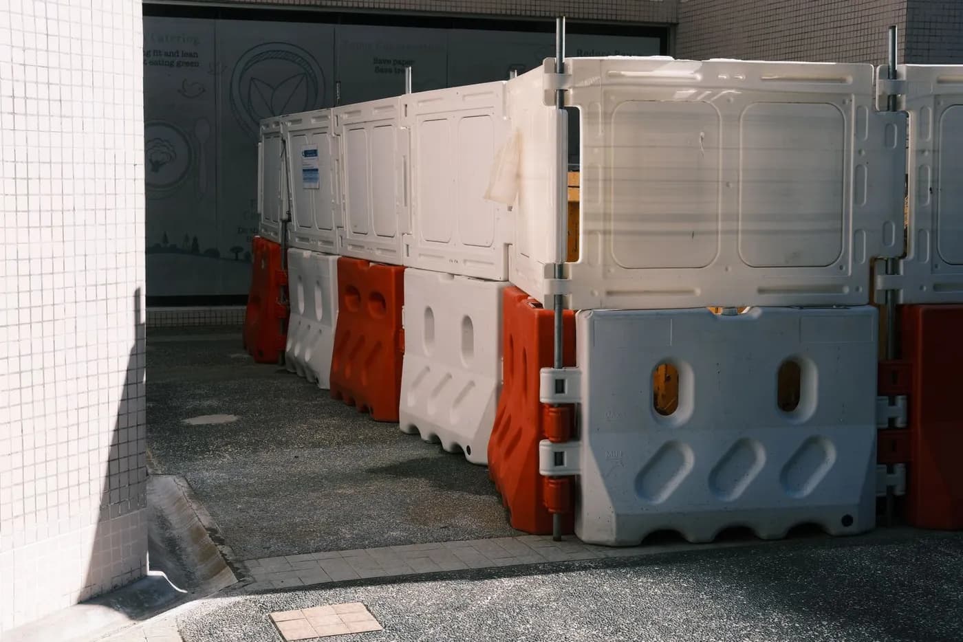 Stacked plastic and steel crowd-control barriers held in a storage yard.