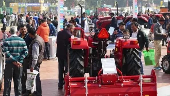 A crowded outdoor trade-fair ground with exhibitor stands and agricultural machinery.