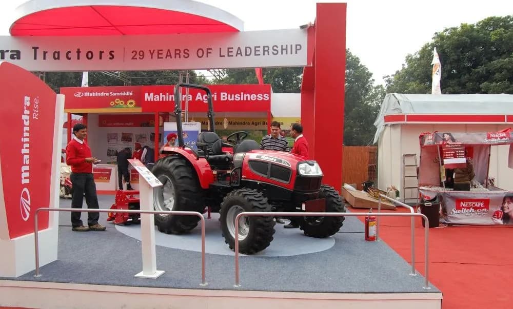 A fabricated exhibition stall with branded fascia and machinery on display at an agricultural trade fair.