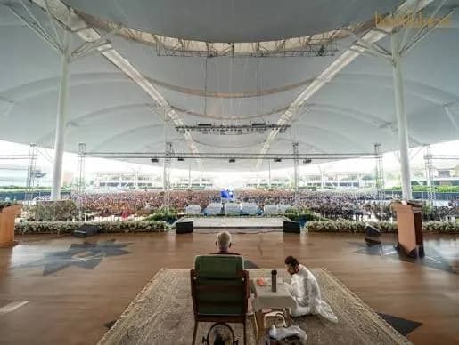 The interior of a tensile clear-span structure, its fabric roof carried on a steel frame.