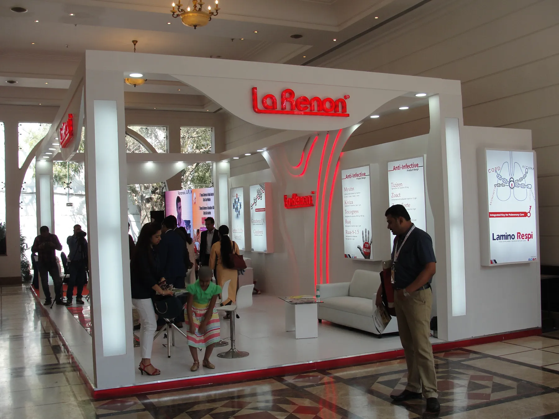 An arched-fascia exhibition stall with visitors passing its frontage.